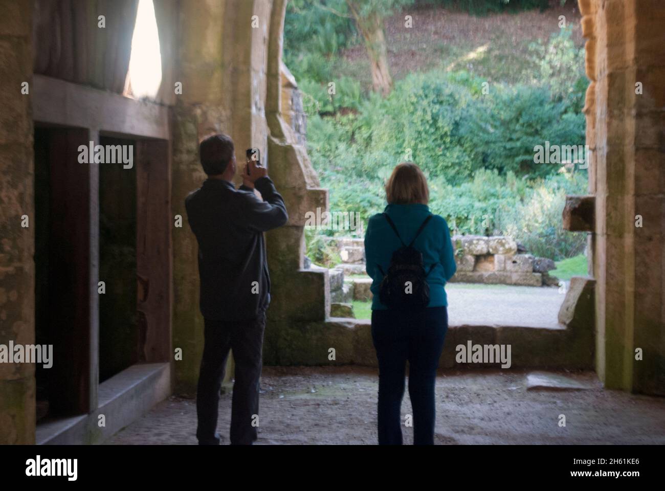 Due persone, una fotografata a Fountains Abbey, Aldfield, vicino a Ripon, North Yorkshire, Inghilterra Foto Stock