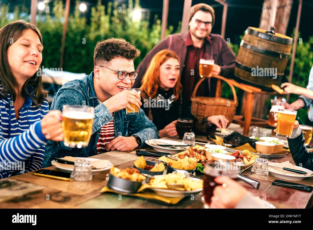 Gli uomini e le donne felici che hanno bevuto la birra alla festa del giardino del patio - concetto sociale di stile di vita di riunione sui giovani amici che godono del tempo di hangout Foto Stock
