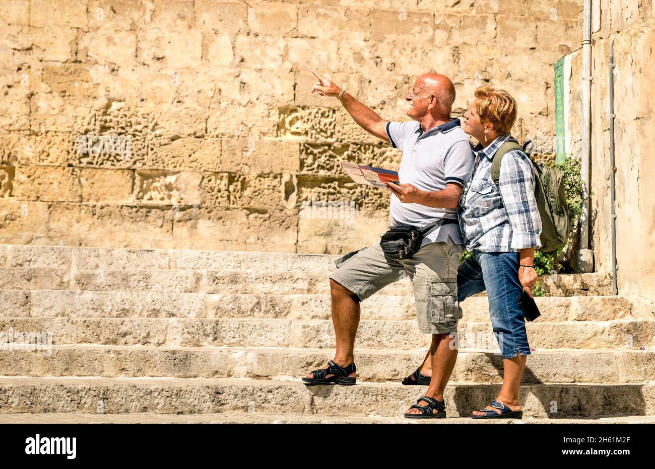 Felice coppia anziana che esplora la città vecchia di la Valletta con mappa della città - concetto di anziano attivo e stile di vita di viaggio senza limiti di età Foto Stock