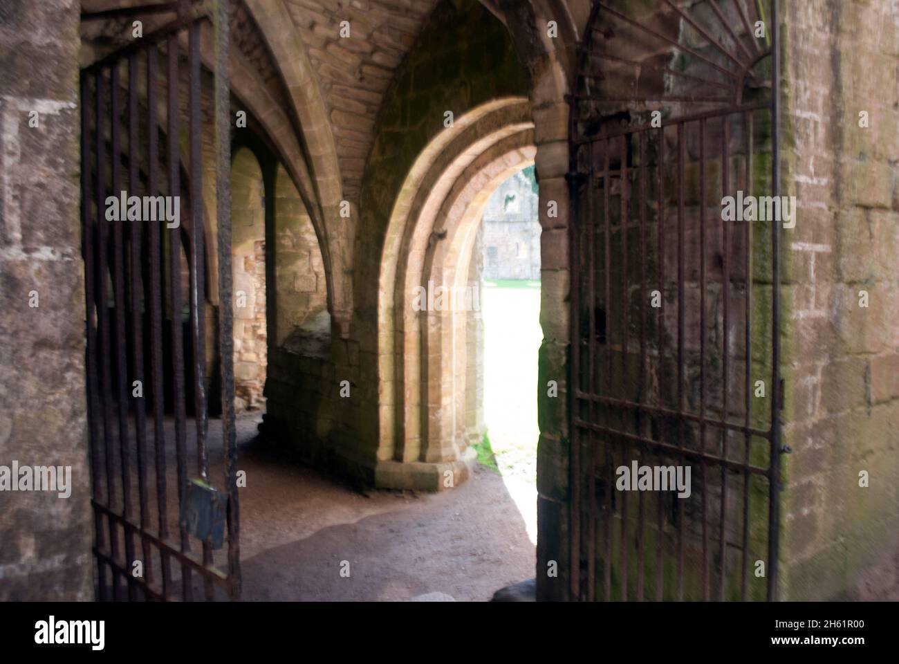 Porte ad arco a Fountains Abbey con porte in ferro, Aldfield, vicino a Ripon, North Yorkshire, Inghilterra Foto Stock