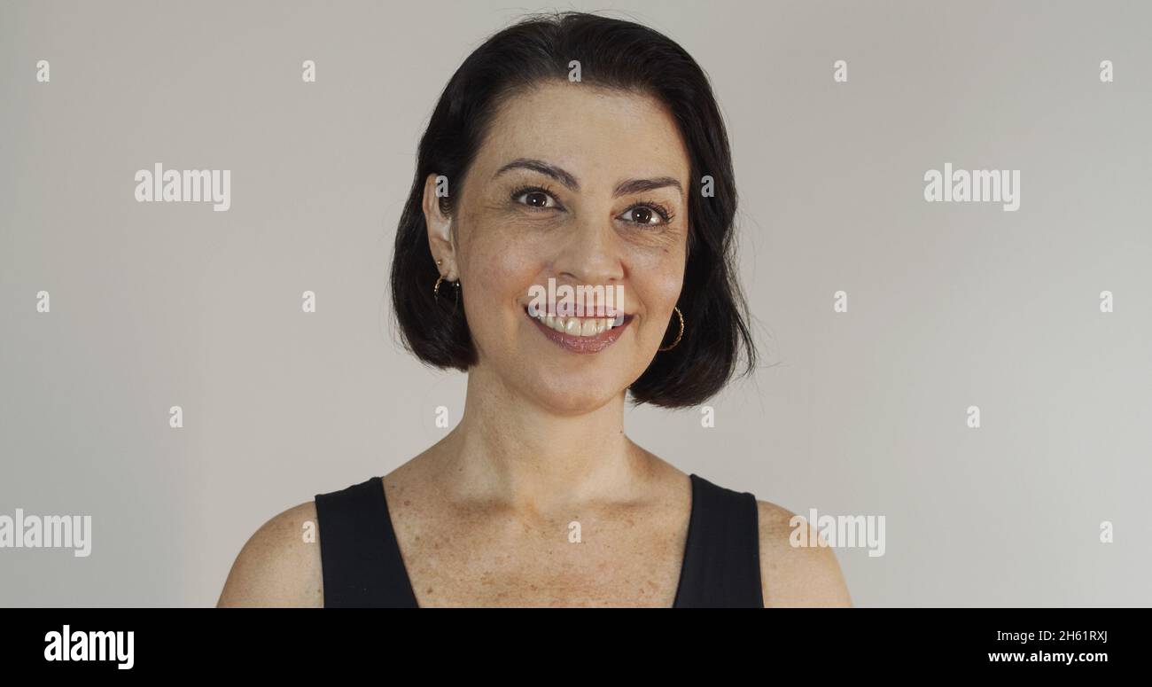 Bella donna di mezza età con bel sorriso sul muro giallo. Donna piuttosto anziana, fiducia riuscita. Foto Stock