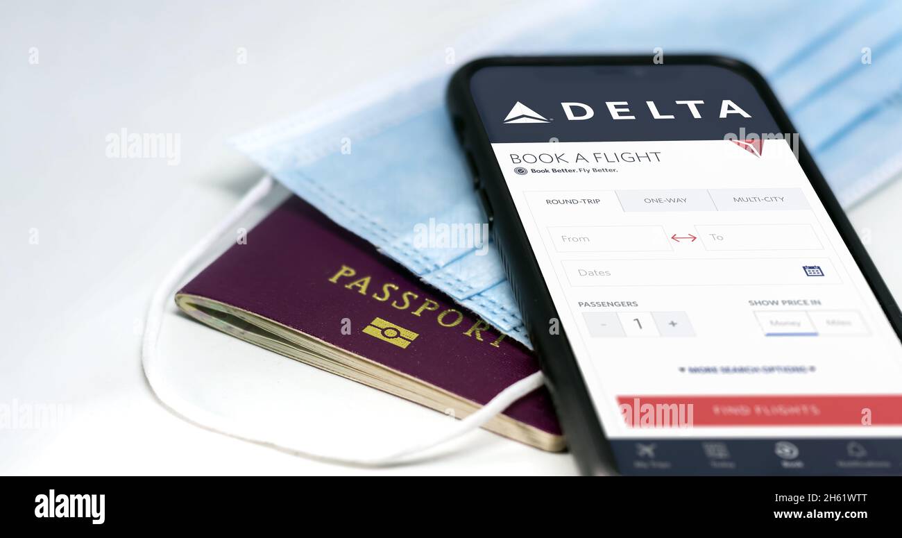 Atlanta, USA, ottobre 2021: Telefona con l'app Delta Airlines sullo schermo sopra una maschera chirurgica e un passaporto. Delta è una delle principali compagnie aeree di Foto Stock