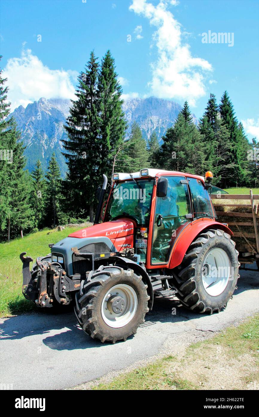 vecchio su lindner geotrac 73,3300 cm–³,3 cilindri,bj. 2009,trattore alla raccolta del fieno,germania,baviera,alta baviera,terra di werdenfelser,valle di isar,mittenwald,kranzberg,wildensee,buckelwiesen,montagne di karwendel,carro di fieno Foto Stock