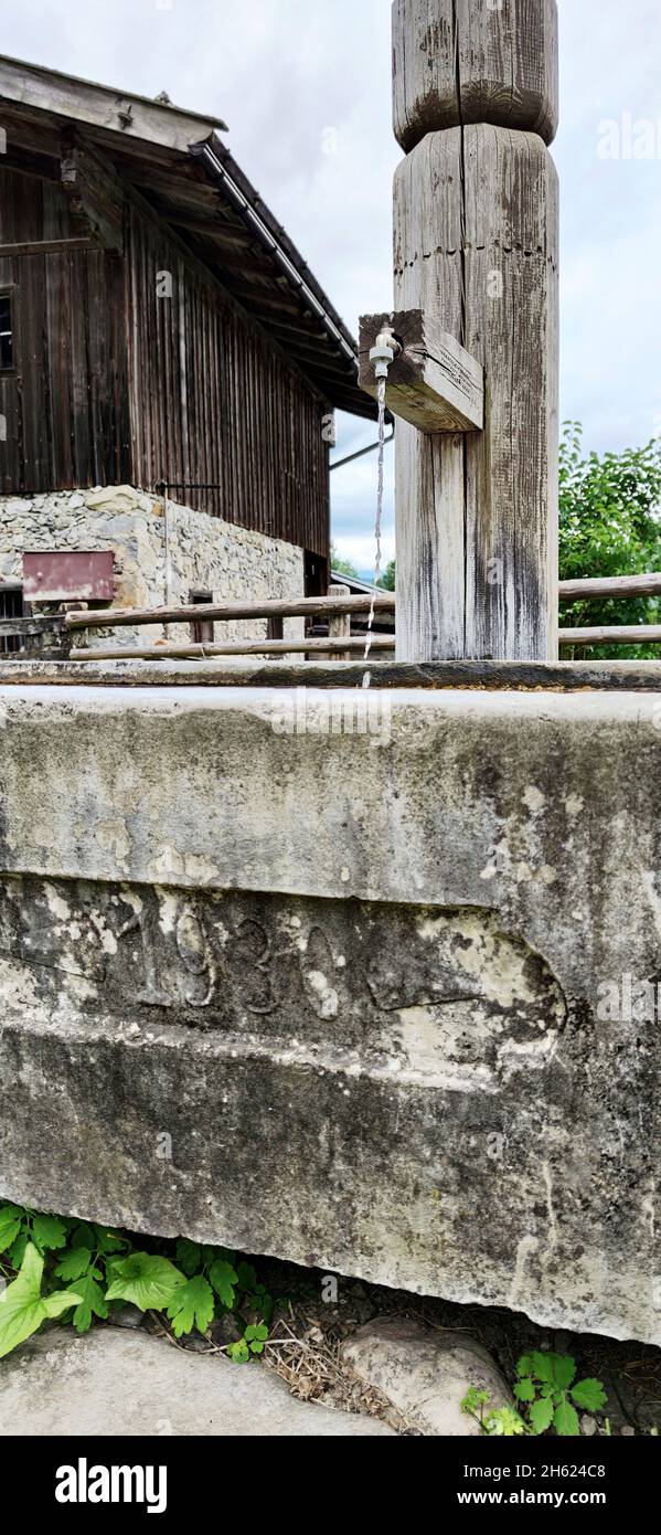 antica fontana del 1930 presso le fattorie montane della regione di brixlegg, tirolo Foto Stock