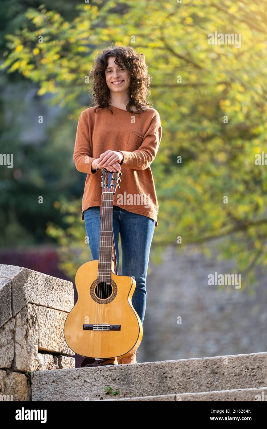 Ragazza in posa davanti alla macchina fotografica con la sua chitarra spagnola Foto Stock