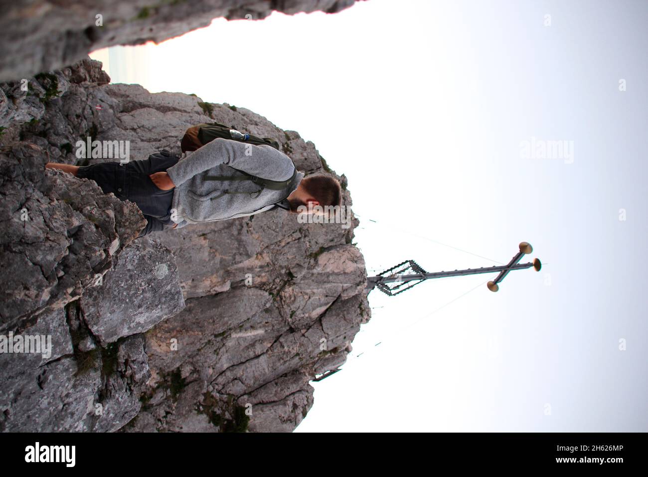 giovane uomo appena sotto la croce sommitale del kampenwand (1669 m) nel chiemgau, alpi chiemgau, vicino aschau, alta baviera, baviera, germania meridionale, germania Foto Stock