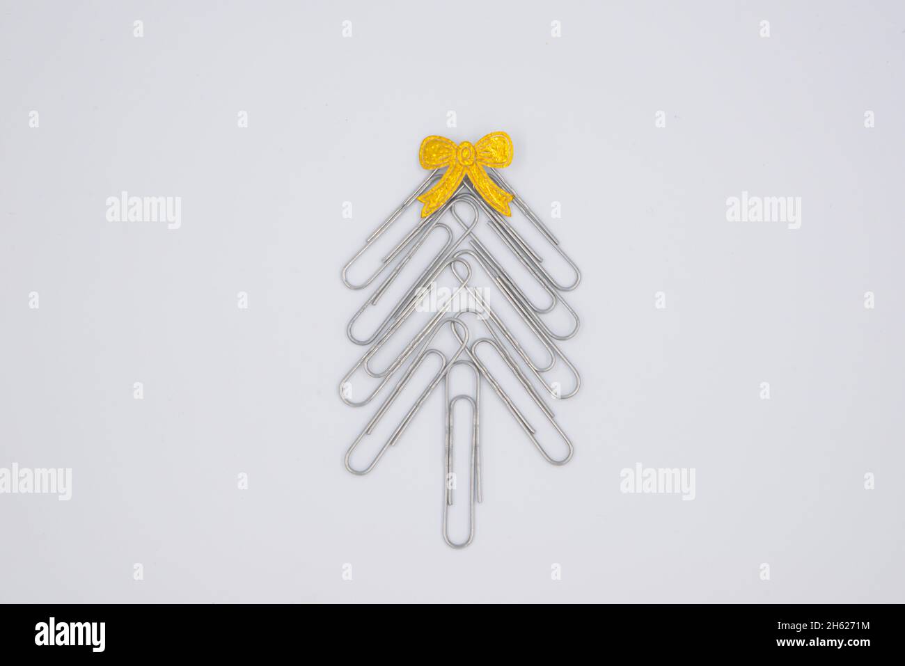 Concept allegro Natale in ufficio. Albero di Natale fatto di clip di carta sullo sfondo bianco. Clip di carta albero di Natale. Sfondo di Natale. Foto Stock