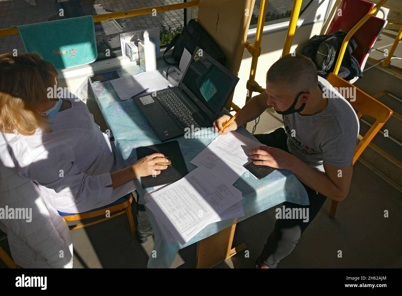 ODESA, UCRAINA - 12 NOVEMBRE 2021 - Un uomo firma un consenso informato in un tram di vaccinazione COVID-19 di stanza in Starosinna Square, Odesa, Regno Unito meridionale Foto Stock