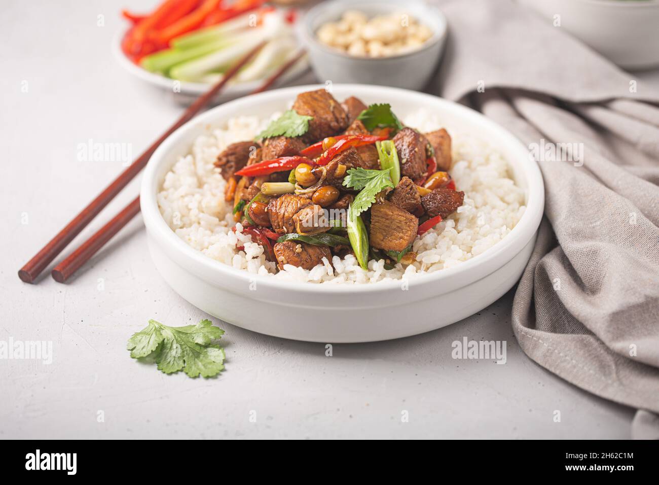 Kung pao o Kung po, cibo tradizionale cinese preparato con carne di pollo, manzo o maiale, a volte frutti di mare, con riso come contorno, backgro in cemento Foto Stock