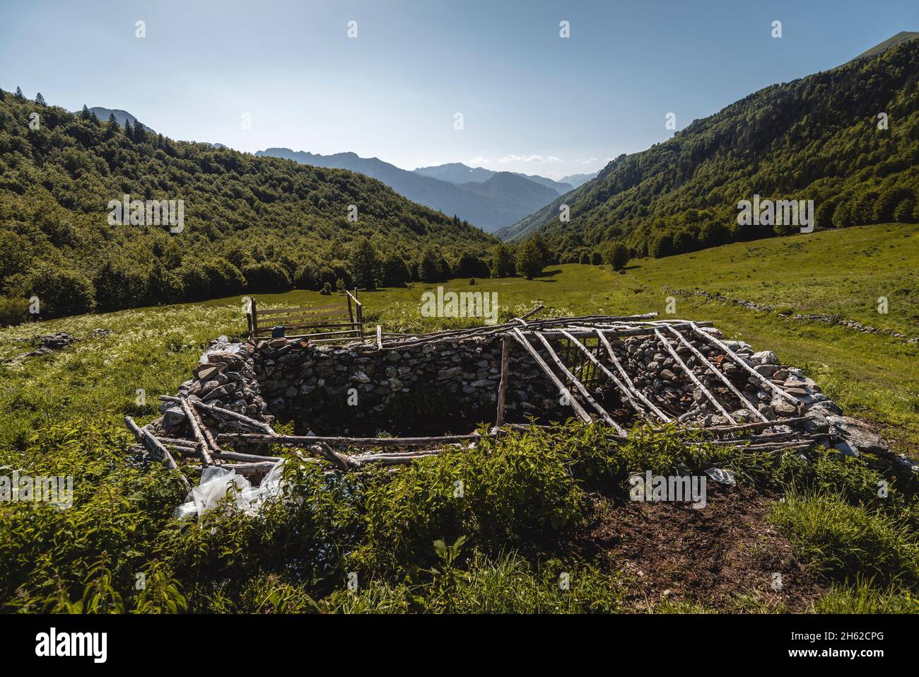 resti di un vecchio edificio in pietra nel mezzo di un verde pascolo, montenegro, parco nazionale prokletije Foto Stock