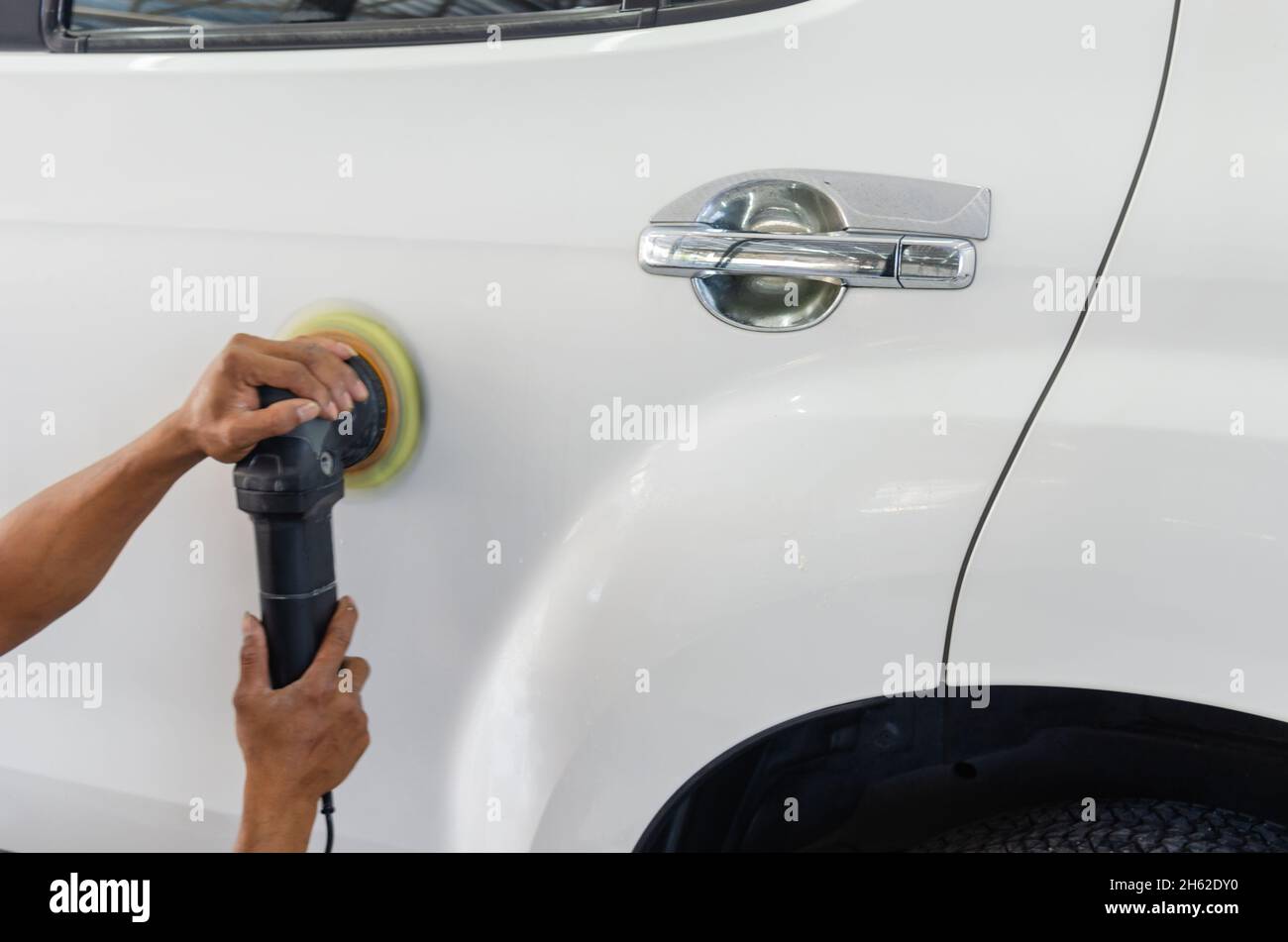 Uomo che lavora per la lucidatura, rivestimento automobili. la lucidatura delle auto potrà aiutare a eliminare i contaminanti sulla superficie della vettura.La ceretta la superficie della vettura sarà c Foto Stock