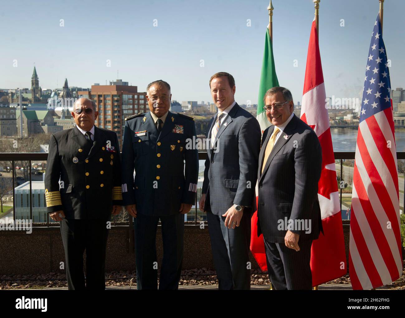 Da sinistra, Segretario messicano della Difesa Nazionale Gen. Guillermo Galvan Galvan, Segretario messicano della Marina Vice-Ammiraglio Mariano Francisco Saynez Mendoza, Il ministro canadese della Difesa nazionale Peter MacKay e il segretario americano della Difesa Leon E. Panetta posano per un ritratto di famiglia sul tetto del Lester B. Pearson Building prima del trilaterale a Ottawa, Canada, martedì 27 marzo 2012. Raffigurata sullo sfondo è la città di Ottawa e Canadian Parlaiment (a sinistra). Foto Stock