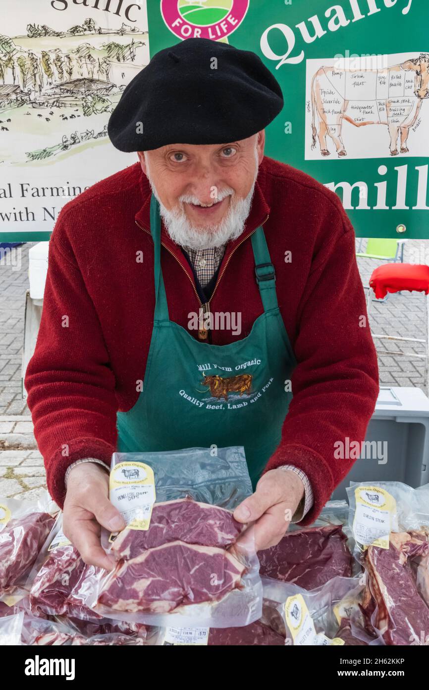 inghilterra,hampshire,petersfield,mercato agricolo settimanale,ritratto di anziano signore che vende carne biologica fresca Foto Stock