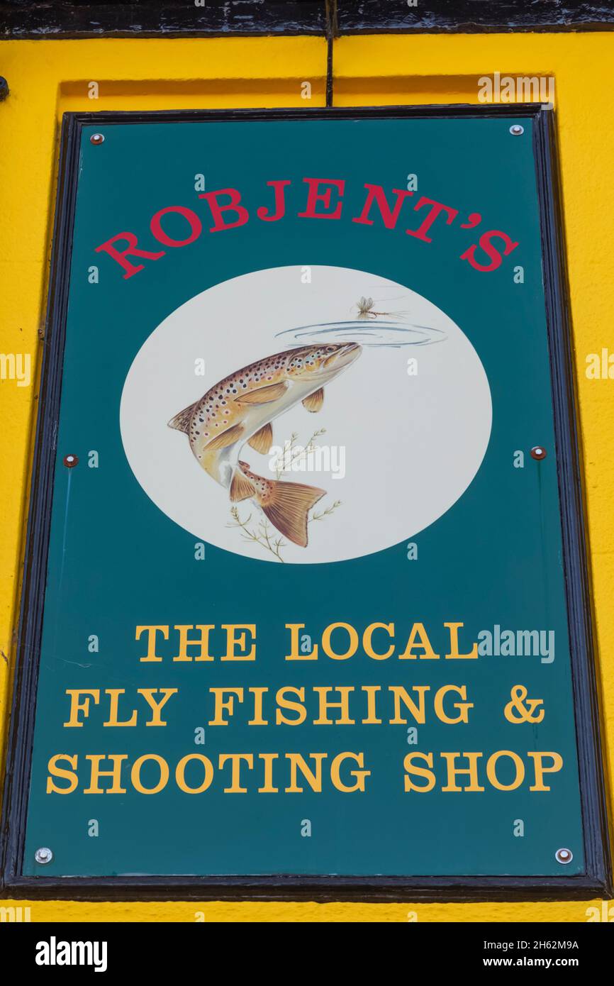 inghilterra, hampshire, test valley, stockbridge, il cartello del negozio di articoli sportivi di robjent raffigurante una trota e una mosca da pesca Foto Stock