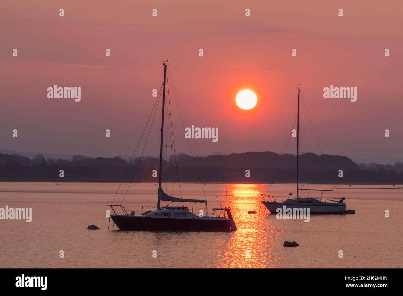 inghilterra, hampshire, langstone, alba con due yacht sul porto di chichester Foto Stock