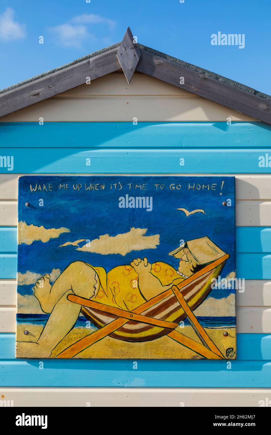 inghilterra, hampshire, hayling island, divertente pittura di donna addormentata grasso in sedia a sdraio sul lato di capanna colorata spiaggia Foto Stock