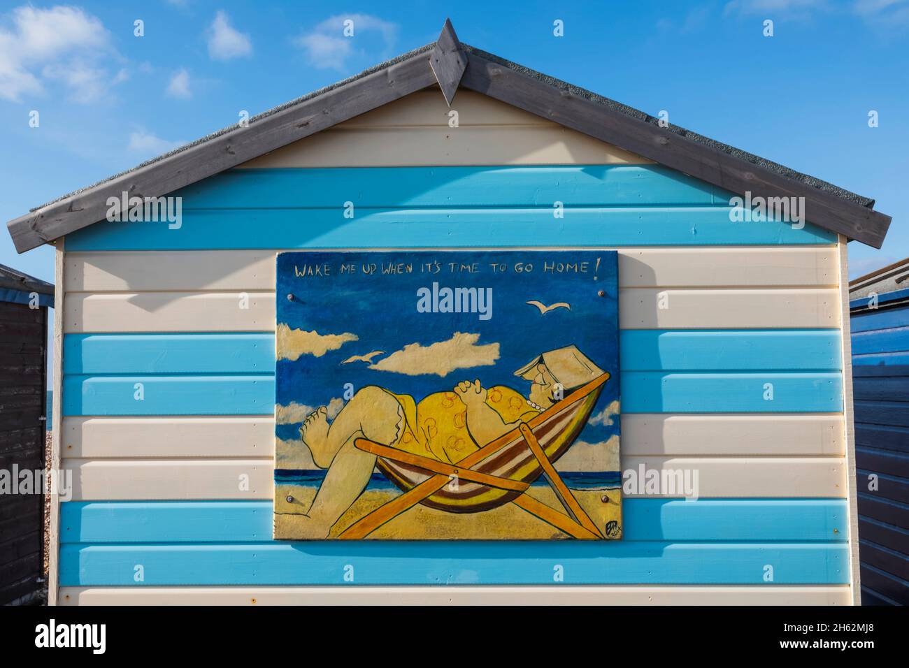 inghilterra, hampshire, hayling island, divertente pittura di donna addormentata grasso in sedia a sdraio sul lato di capanna colorata spiaggia Foto Stock