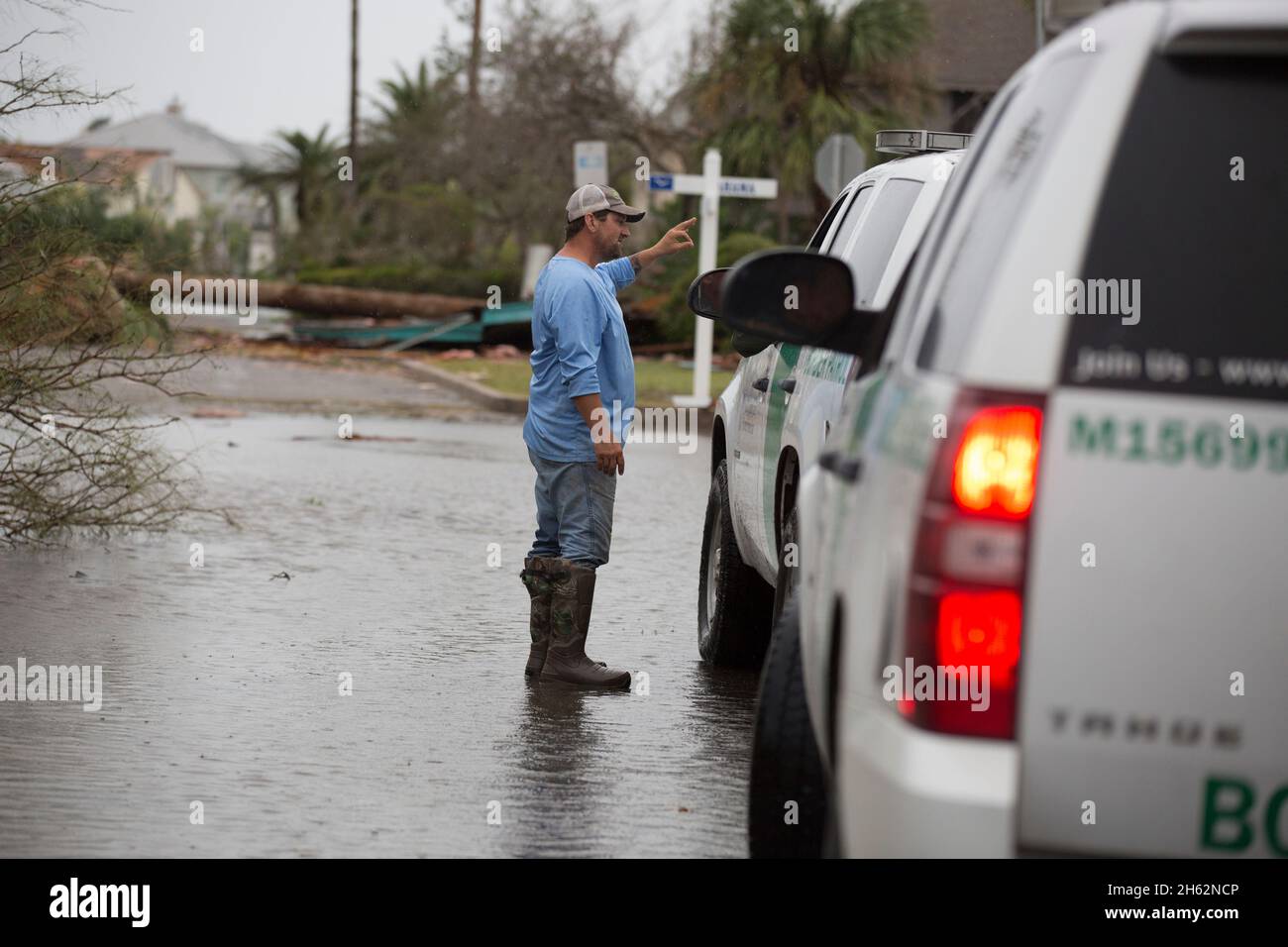 Un agente della pattuglia di confine degli Stati Uniti parla con un Rockport, Texas, residente come lui e altri agenti pattuglia un quartiere devastato dall'uragano Harvey 26 agosto 2017. I membri della pattuglia di frontiera degli Stati Uniti sono sul terreno agenti che conducono le operazioni di recupero e di salvataggio in seguito all'uragano che ha fatto la caduta del venerdì sera. Foto Stock
