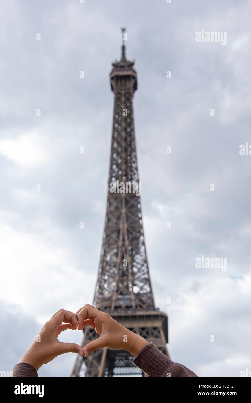 francia,parigi,ãžle-de-france,due mani che formano un cuore di fronte alla torre eiffel Foto Stock