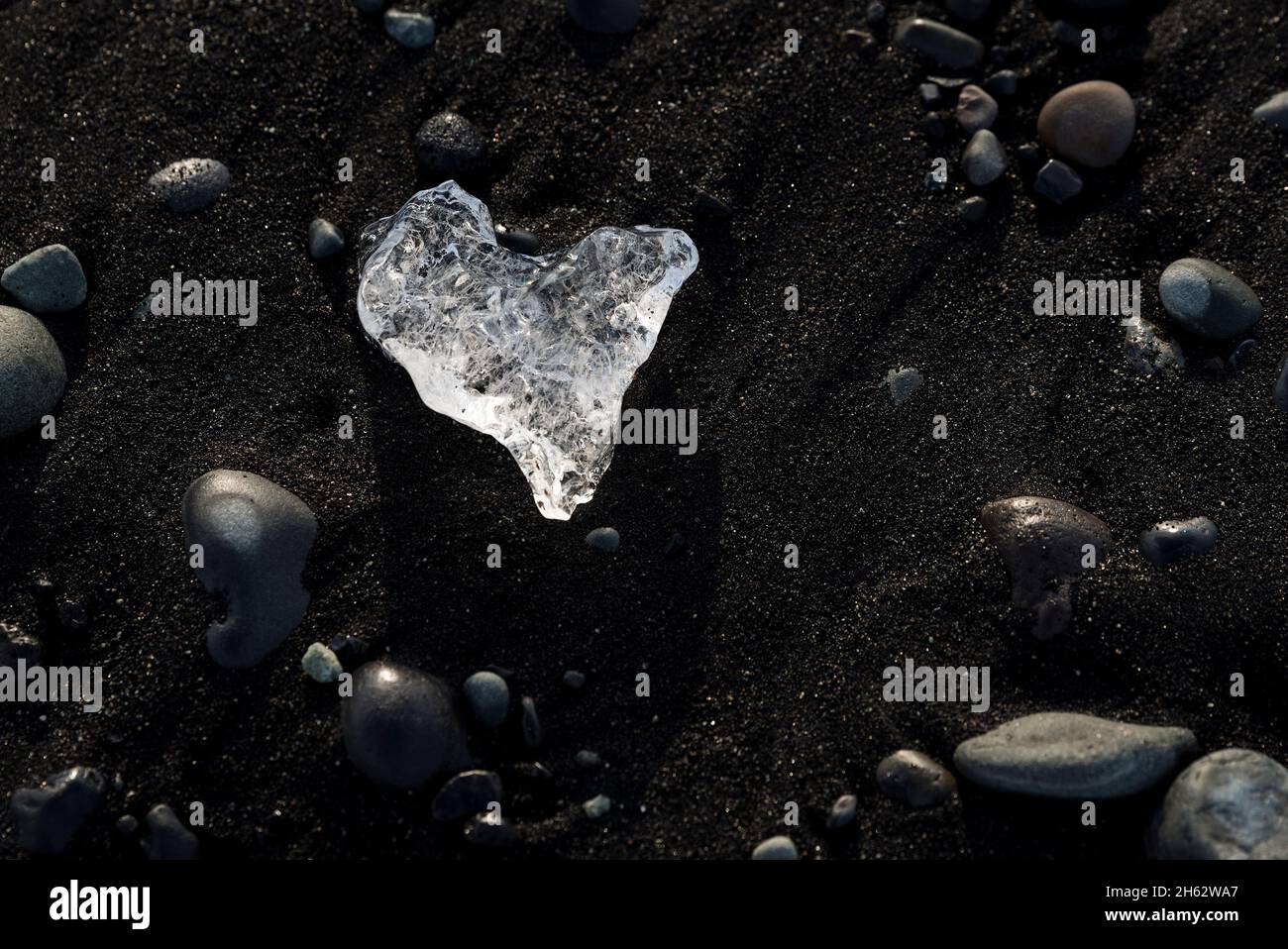 pezzo di ghiaccio a forma di cuore sulla spiaggia nera, tratto di costa vicino alla laguna del ghiacciaio jokulsarlon, parco nazionale vatnajokull, islanda Foto Stock