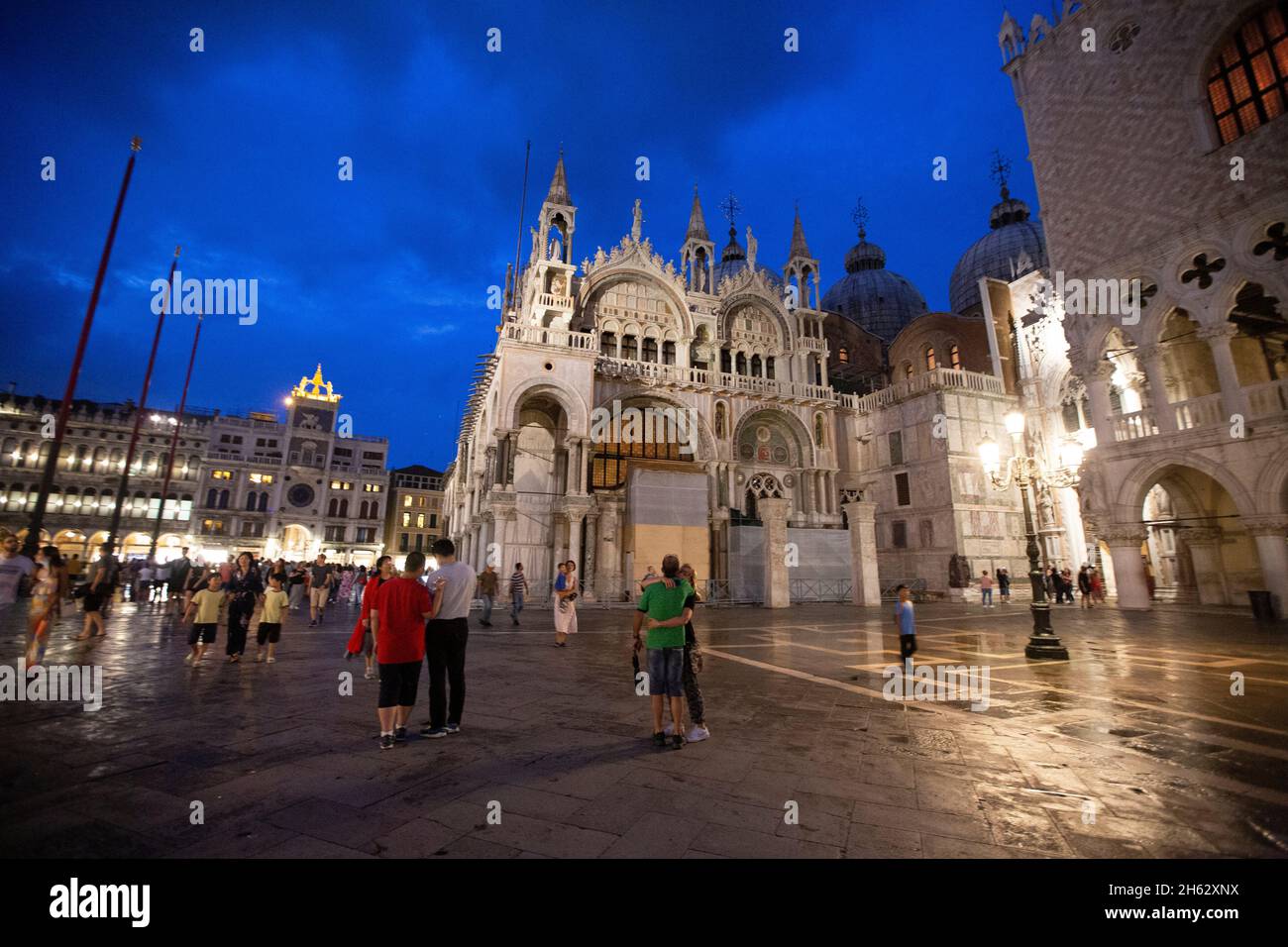 fantastica notte in piazza san marco con campanile e basilica di san marco. colorato paesaggio urbano serale di venezia, italia, europa con molta acqua riflettente. Foto Stock