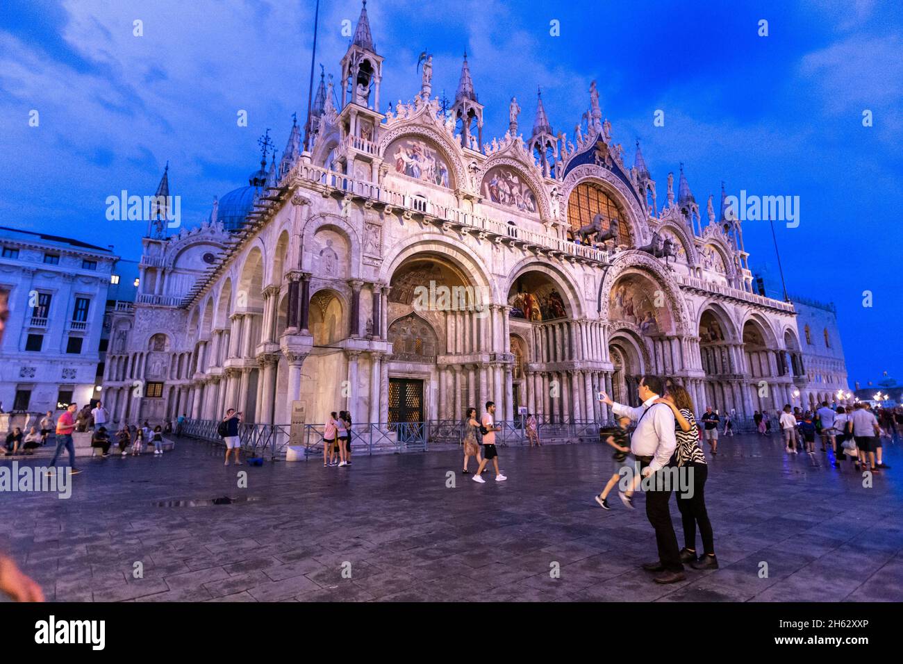 fantastica notte in piazza san marco con campanile e basilica di san marco. colorato paesaggio urbano serale di venezia, italia, europa con molta acqua riflettente. Foto Stock