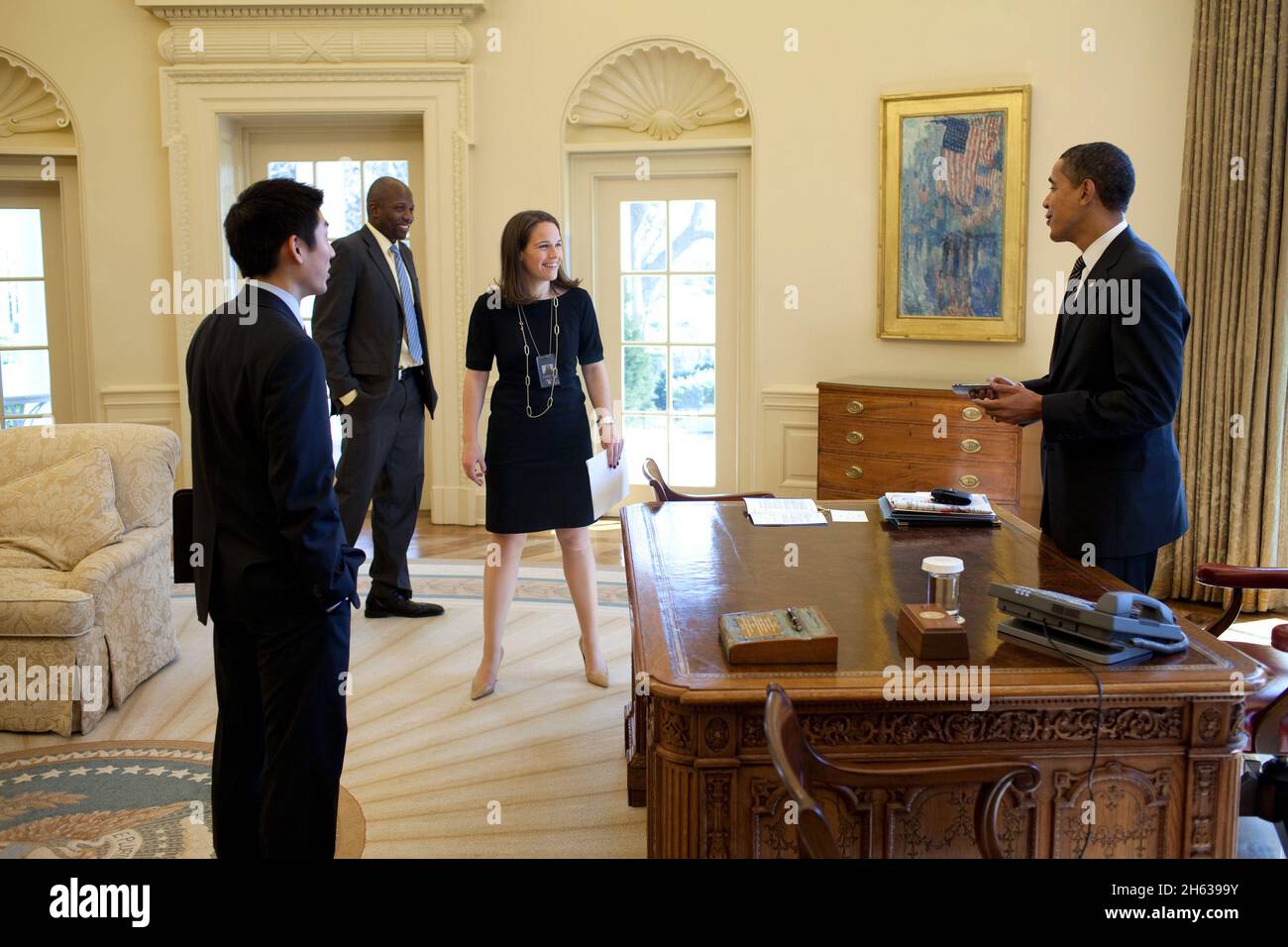 Il Presidente Barack Obama scherza con l'Assistente Speciale Eugene Kang, il Segretario personale Katie, Johnson e l'Aide Reggie Love personale nell'Ufficio ovale 3/5/09. Foto Stock