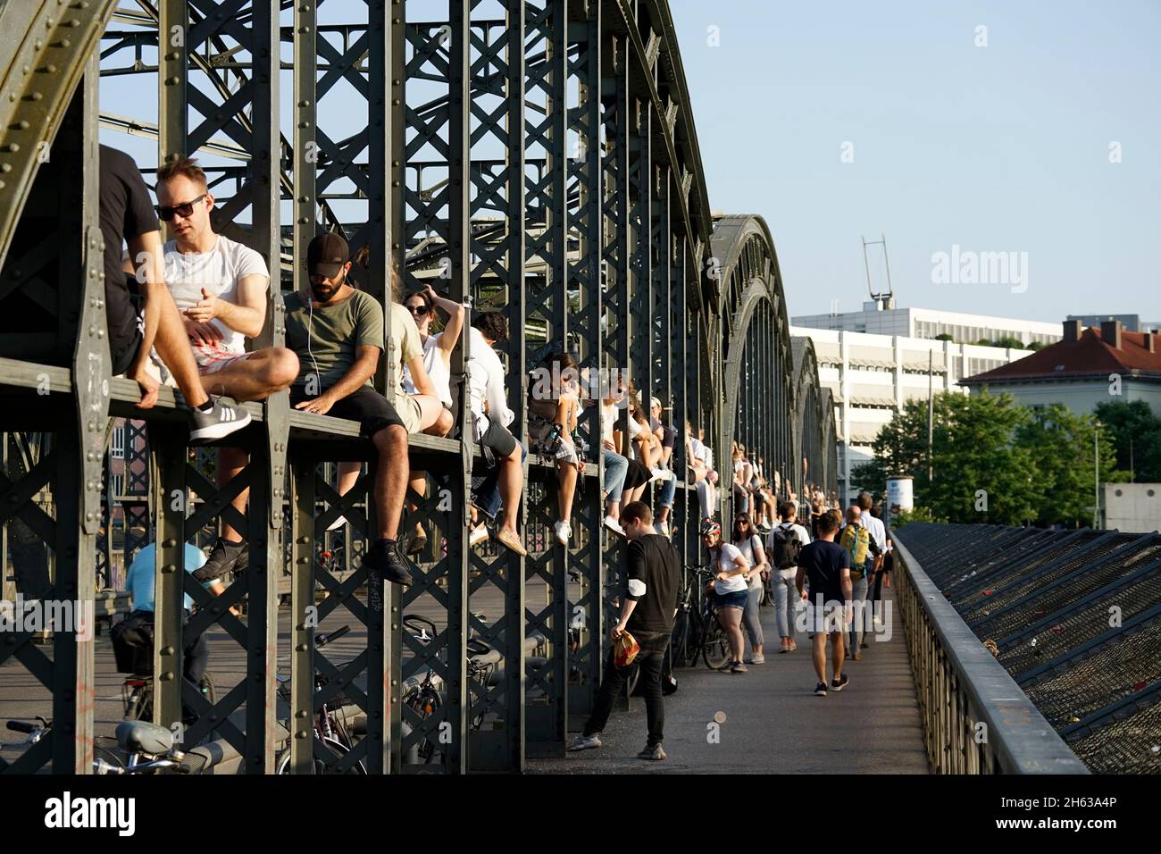 germania,baviera,monaco,stazione centrale,haccurbrücke,giovani siedono sulla struttura di ferro,chill,attendere il tramonto Foto Stock