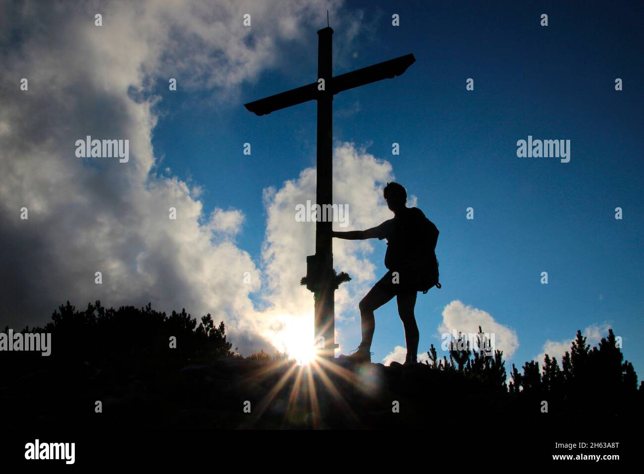 uomo alla croce di cima, escursione al gap 1829m, estergebirge, tramonto, retroilluminazione, tenendo croce, europa, germania, baviera, alta baviera, werdenfelser terra, alpenwelt karwendel, isar valle, krün Foto Stock
