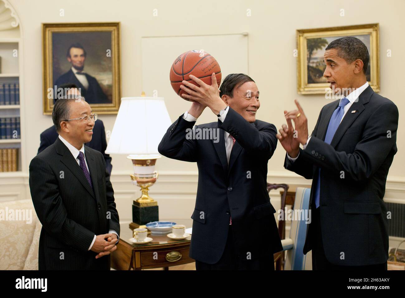 Il Vice Premier cinese Wang Qishan, centro, tiene il basket dato a lui dal Presidente Barack Obama dopo il loro incontro Oval Office martedì 28 luglio 2009, per discutere i risultati del primo dialogo strategico ed economico USA-Cina. Guardando a sinistra si trova il consigliere di Stato cinese dai Bingguo Foto Stock