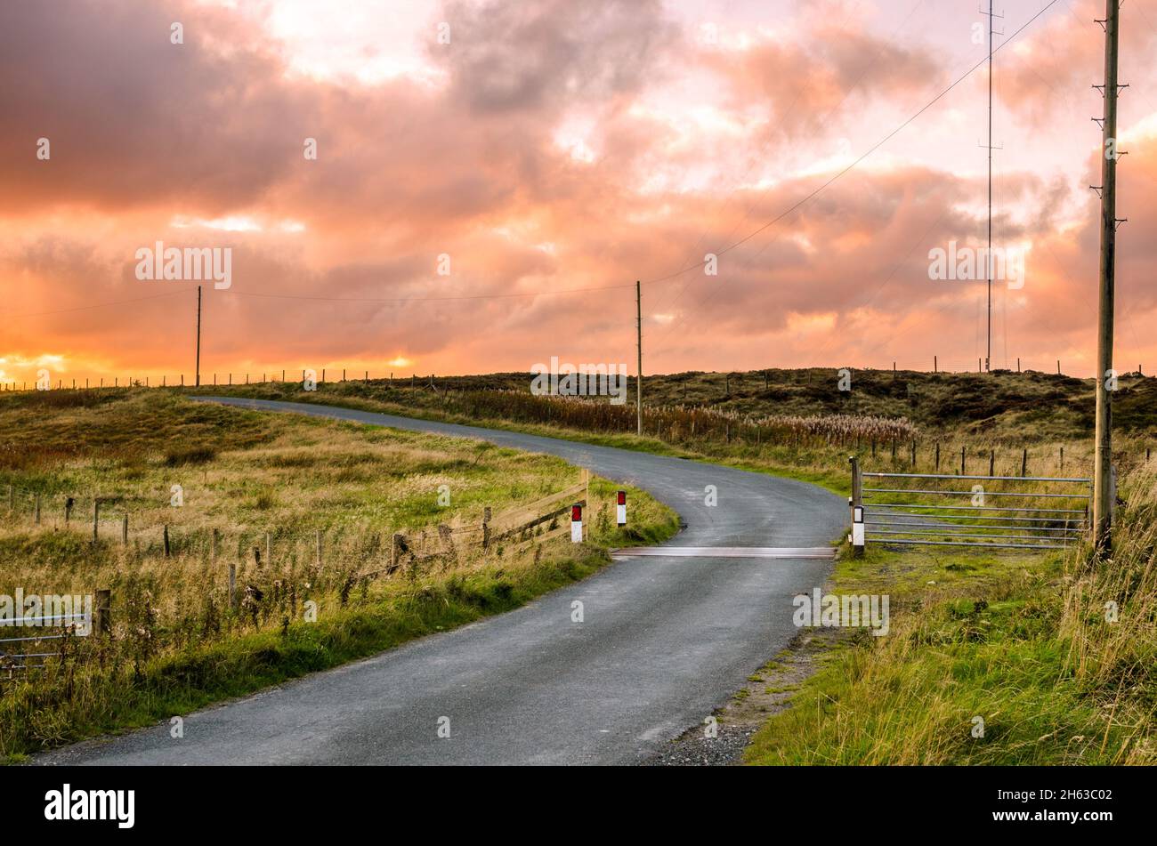 Spettacolare e colorato cielo autunnale su una stretta strada di campagna al tramonto Foto Stock