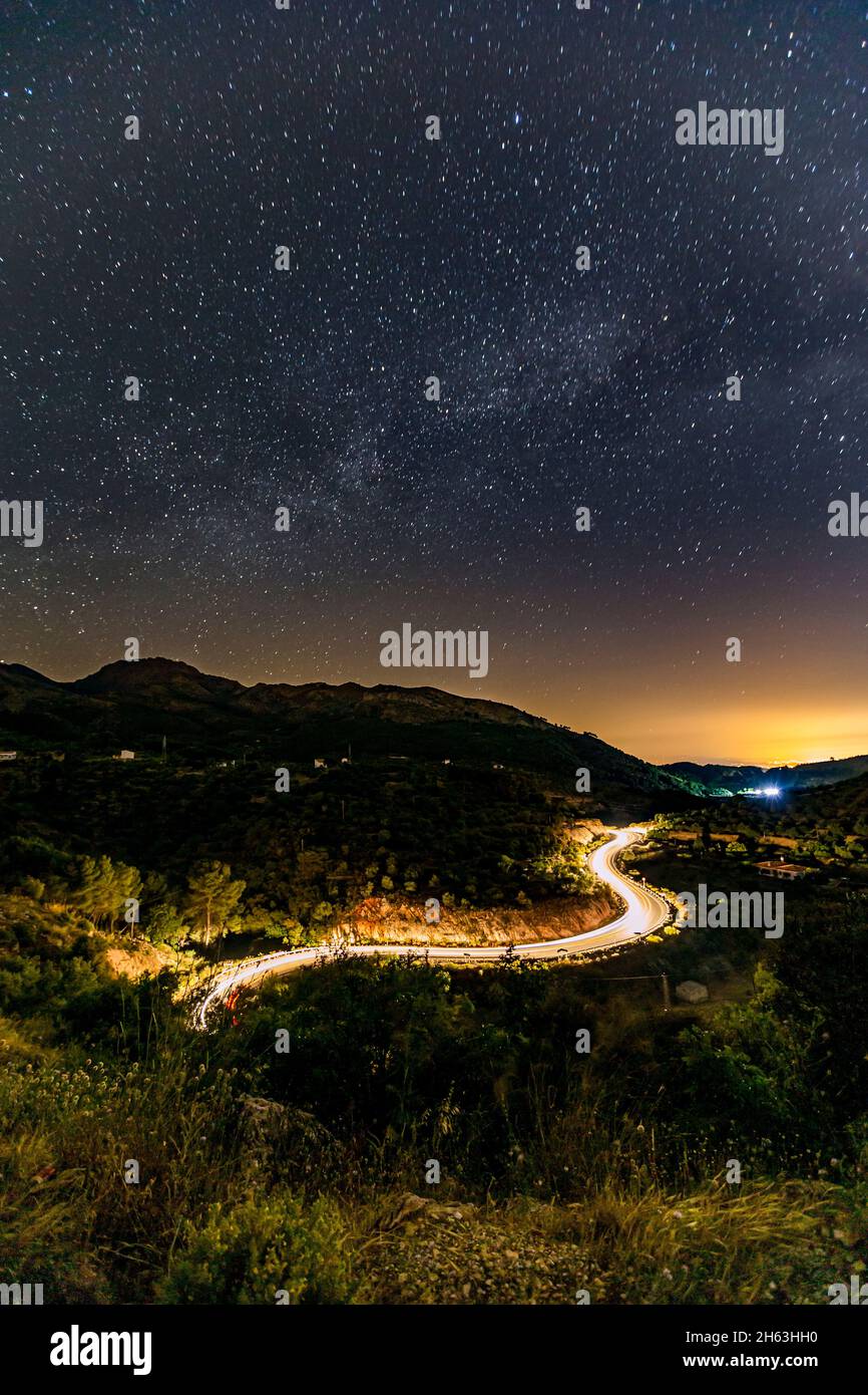 sentiero leggero di automobili su una strada tortuosa con le stelle sopra (modo milkey) in andalusia, spagna Foto Stock