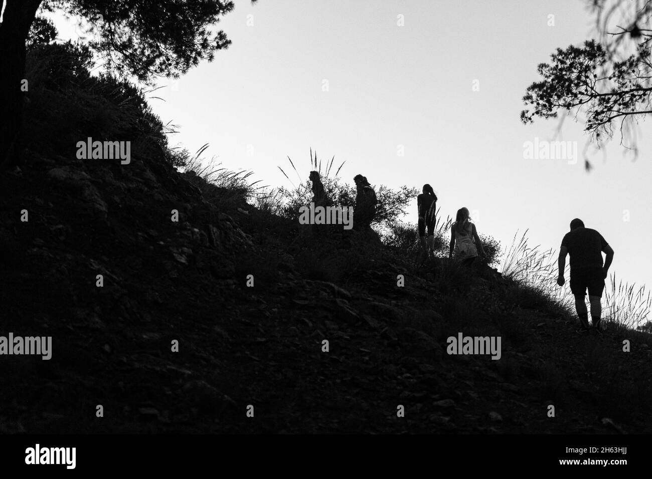 un gruppo di escursionisti che si arrampicano su una collina al mattino presto nel parco naturale della sierra de las nieves, andalusia, spagna Foto Stock