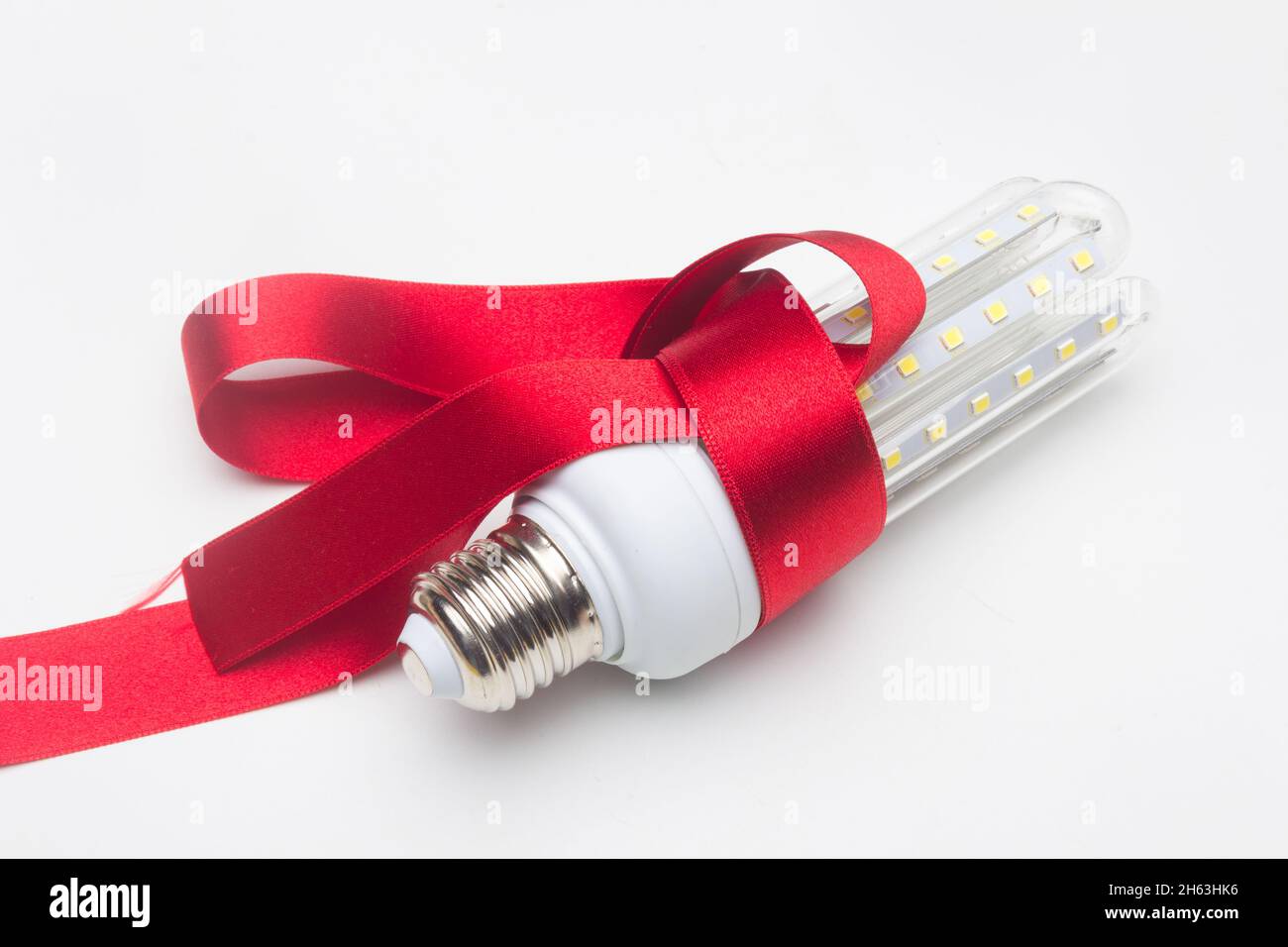 Lampadina ecologica a risparmio energetico e nastro regalo Foto Stock