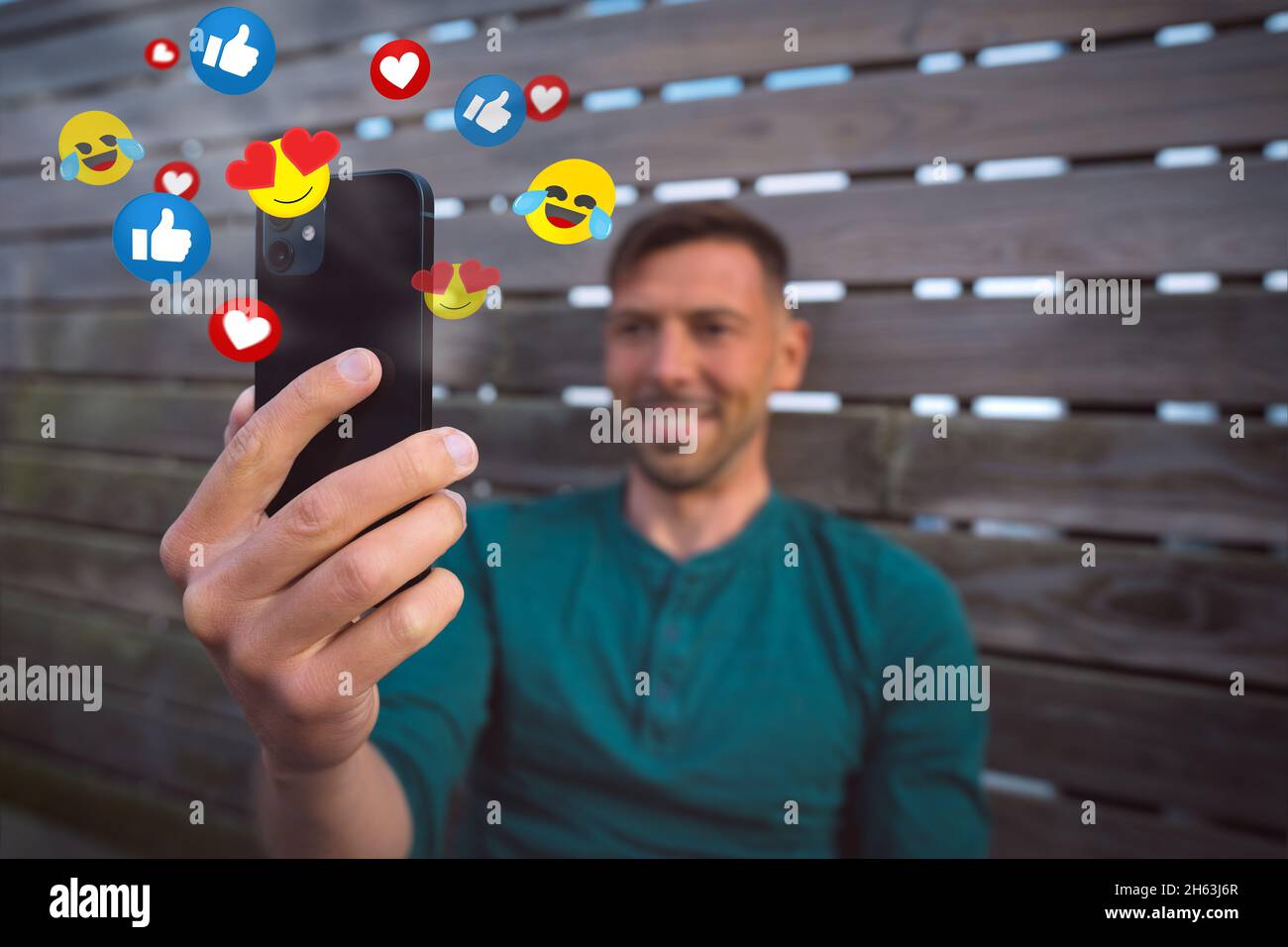 Vlogger streaming di un video dal vivo. Happy man che usa lo smartphone con social media o live streaming Foto Stock