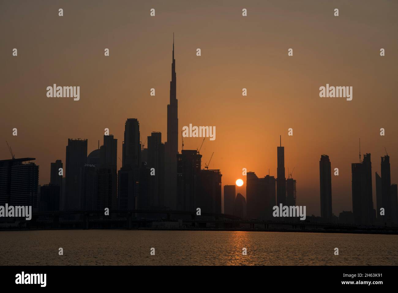 Burj Khalifa e alti edifici al tramonto Dubai Canal UAE Foto Stock