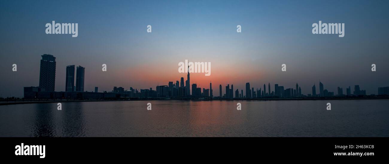 Vista panoramica di Dubai silouhette skyskyslapers al tramonto Dubai Creek UAE Foto Stock
