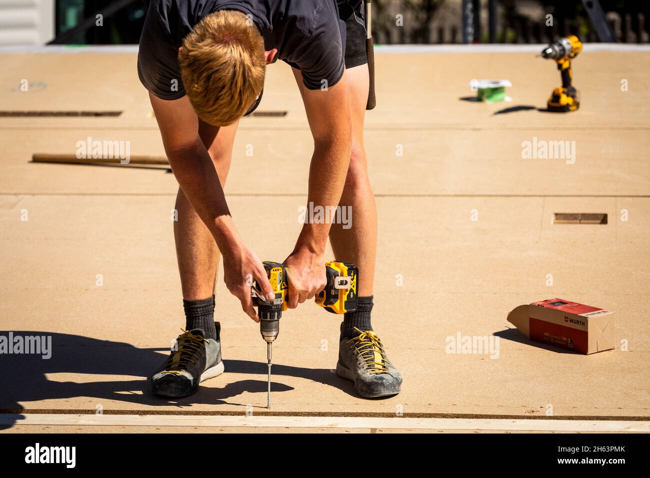 germania,baviera,costruzione di una casa prefabbricata in legno,carpentiere con avvitatore a batteria, Foto Stock