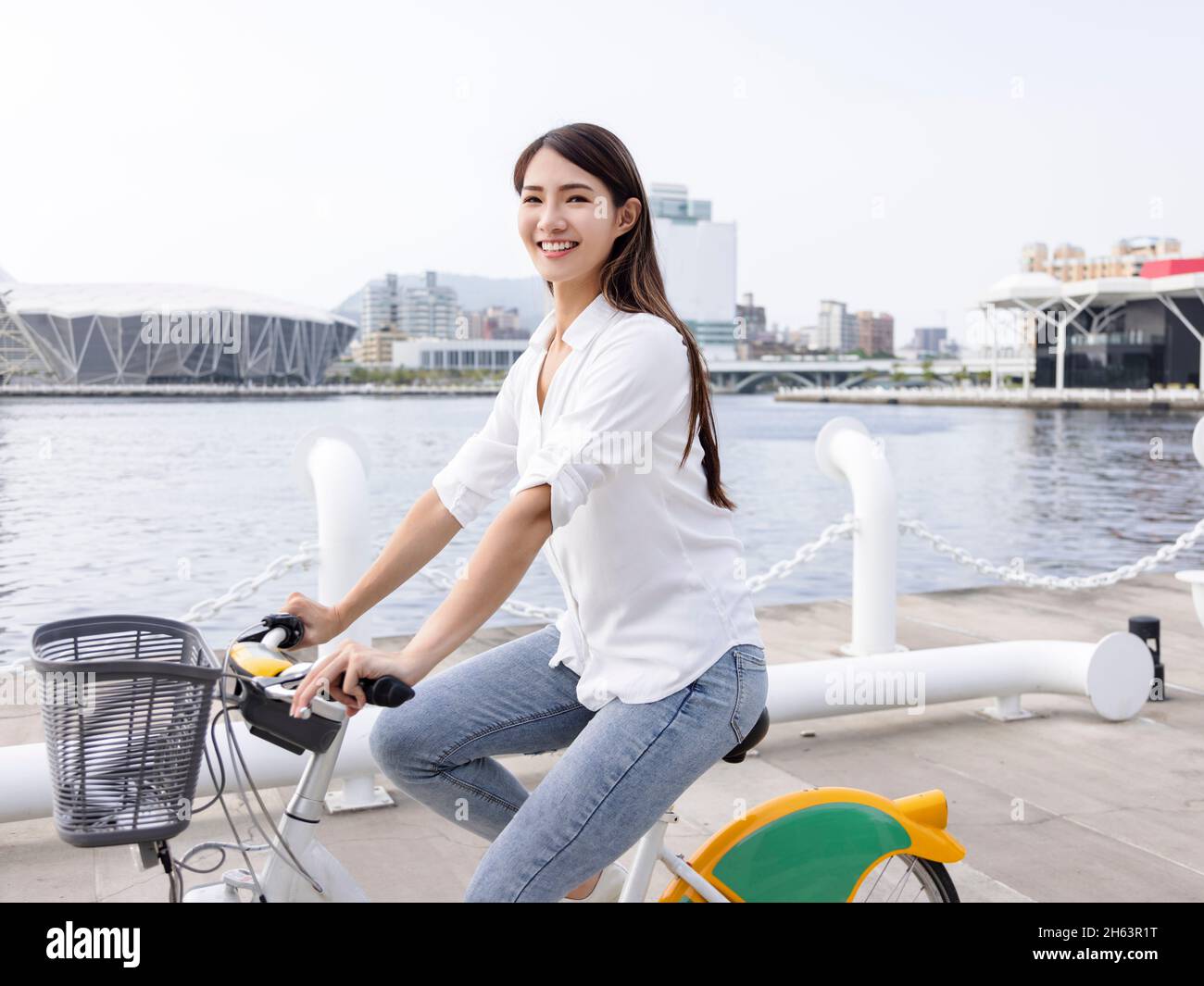 Giovane donna in bicicletta nel parco della città Foto Stock