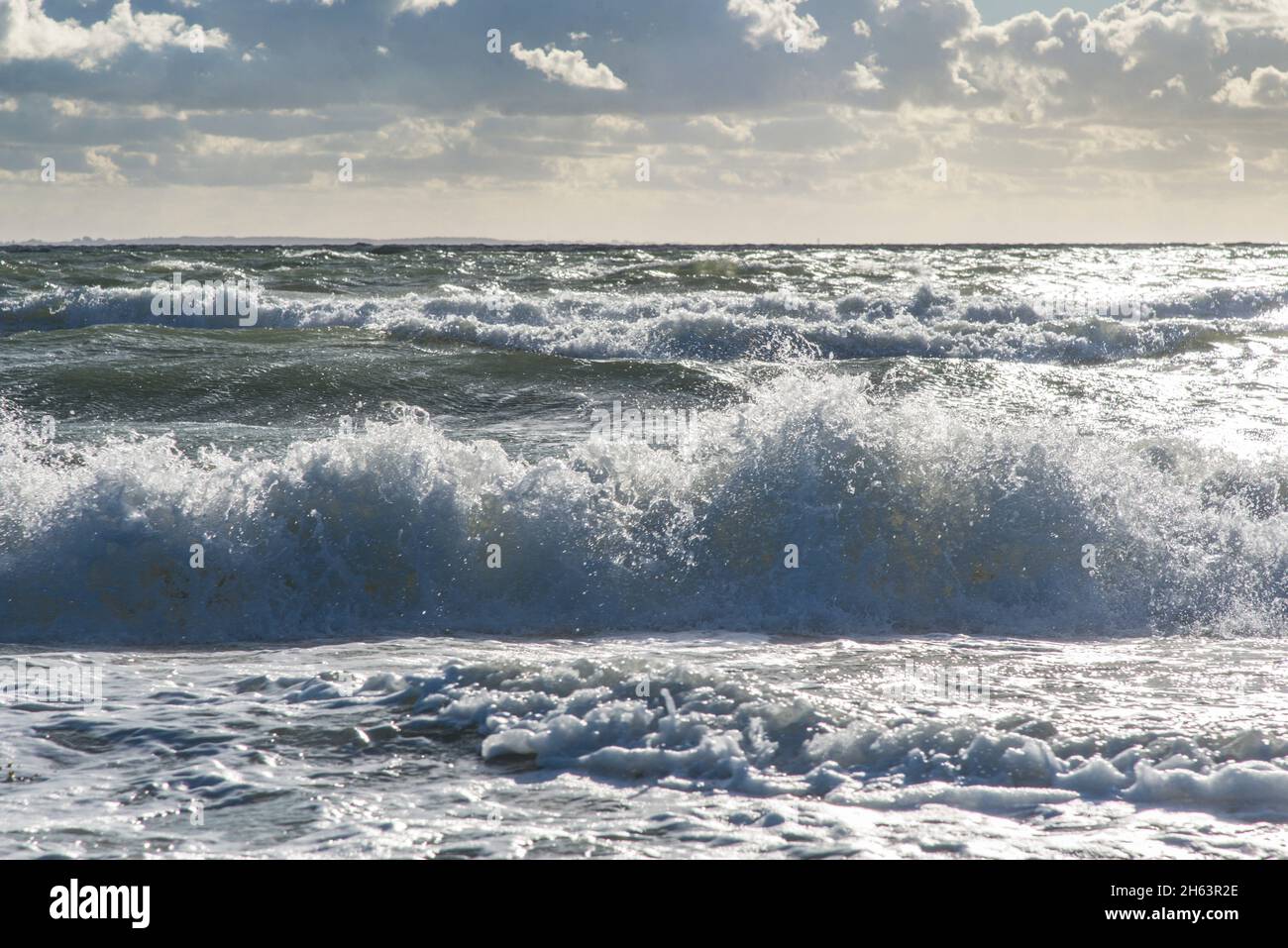 surf onde contro un cielo poco nuvoloso sulla spiaggia di mare nord vicino a neeltje jans. Foto Stock