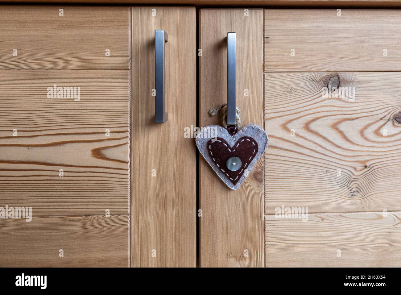 mobili in legno,dettaglio delle porte con un oggetto a forma di cuore Foto Stock
