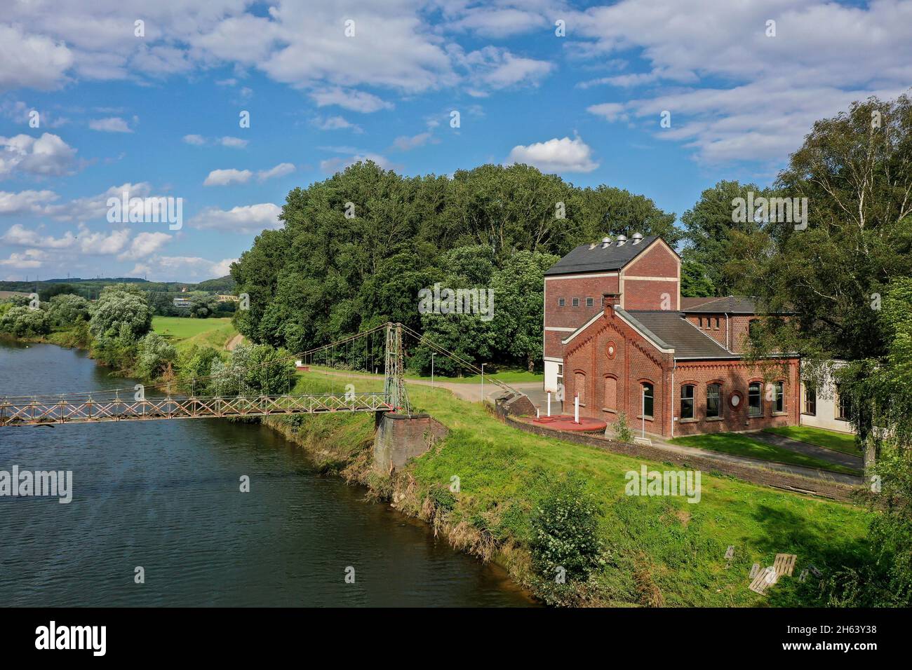 wetter an der ruhr, distretto di ennepe-ruhr, renania settentrionale-vestfalia, germania - impianti idrici comunali di volmarstein, i lavori idrici del 1883, situati direttamente sulla ruhr, sono ancora in funzione oggi. la costruzione in ferro del ponte sospeso della società sulla ruhr, costruito nel 1893, è un raro esempio di questo tipo di costruzione nella storia della tecnologia. Foto Stock