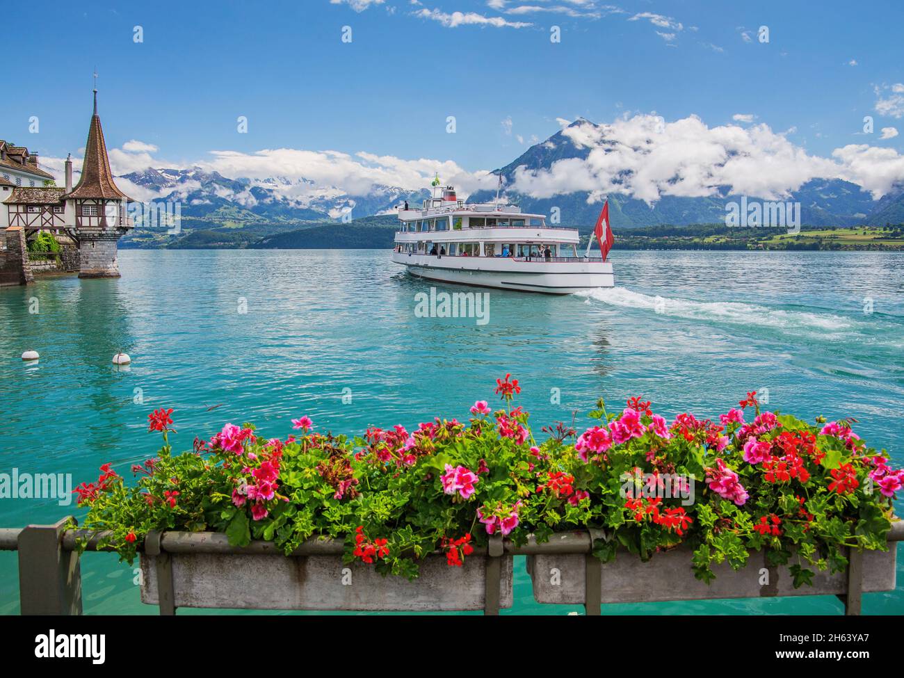 torrette del castello di oberhofen sulla riva del lago con barca da escursione, lago thun, alpi bernesi, oberland bernese, cantone di berna, svizzera Foto Stock
