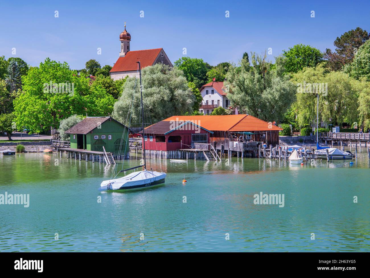 boathouses sul lago con st. jakob chiesa, schondorf, ammersee, voralpensee, colline alpine, alta baviera, baviera, germania Foto Stock