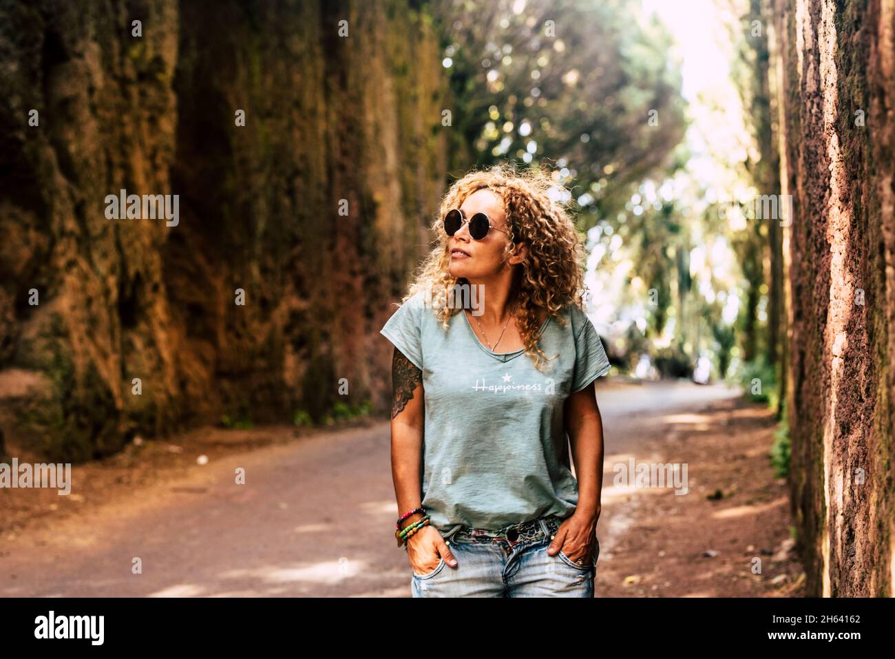 una graziosa donna adulta cammina da sola nella strada panoramica in legno di foresta godendo di attività ricreative all'aperto parco naturale - persone e sfondo naturale Foto Stock