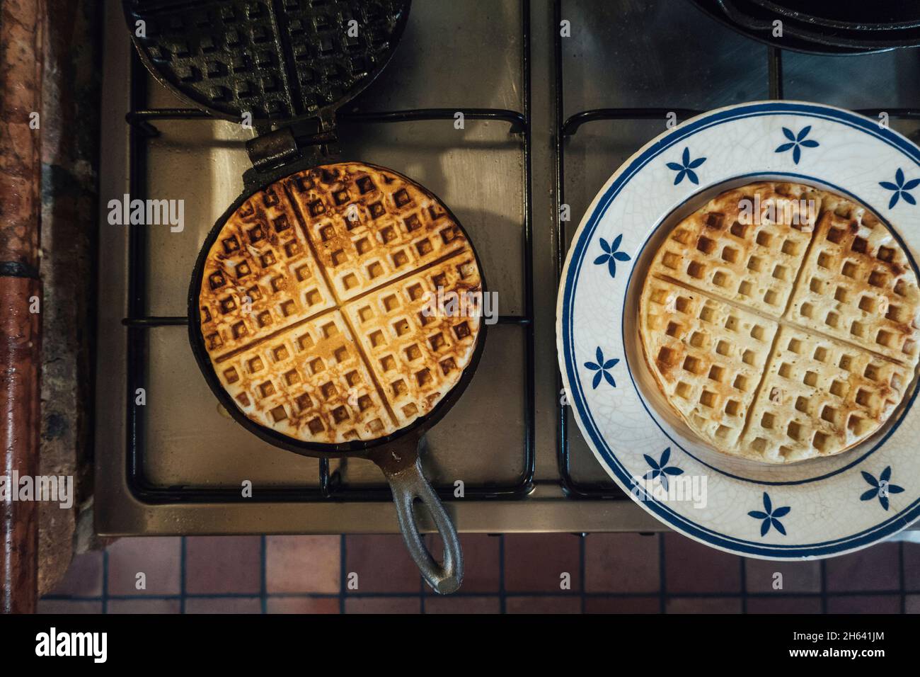 ferro da stiro con waffle appena sfornati in cucina Foto Stock