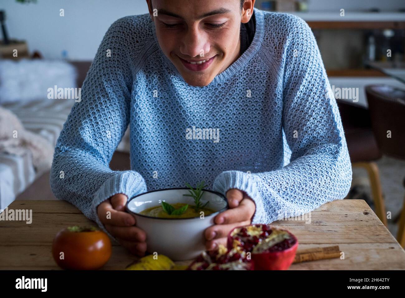 giovane ragazzo ragazzo ragazzo sorriso guardando una zuppa di verdure a casa a pranzo - vegetariano e sano cibo nutrizione concetto di stile di vita - ragazzi e colori autunnali al coperto Foto Stock