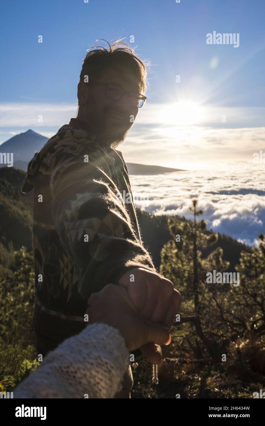 coppia di viaggiatori d'avventura. silhouette di uomo seguire donna tenendo le mani escursioni sul paesaggio di montagna. coppia godere di escursioni sulla cima della montagna Foto Stock