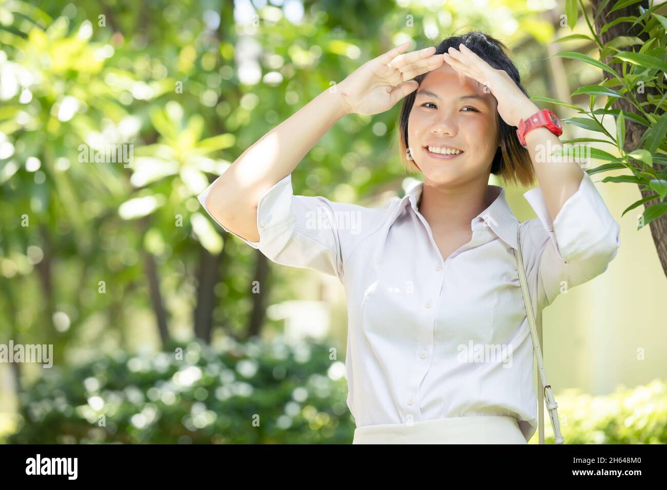 Ritratto Asian donne teen in piedi all'aperto verde con mano parasole auto protezione UV sorriso felice Foto Stock