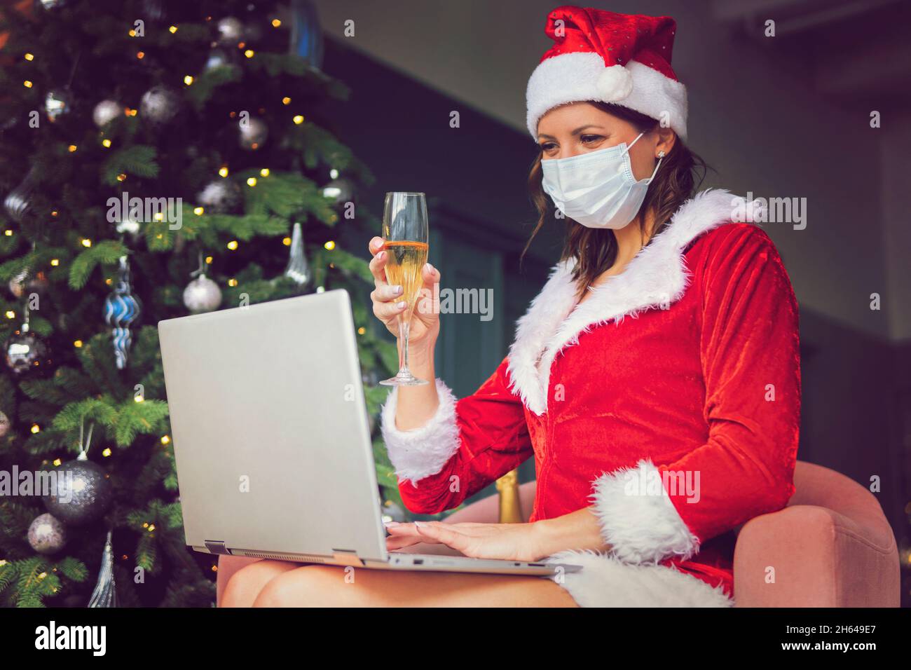 Closdup bella donna asiatica cappello e rosso Babbo Natale sorridente felicemente, champagne vetro, concept vacanza festeggiamento, albero di Natale sfondo. Cristo Foto Stock